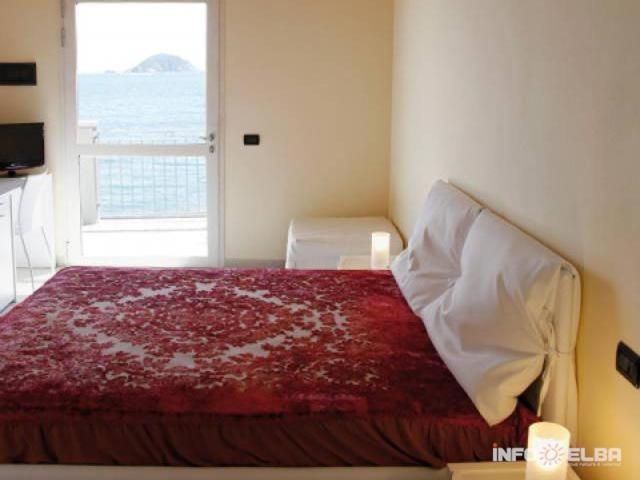 里奥马里纳B&B LE FORNACELLE的一间卧室设有一张大床和窗户