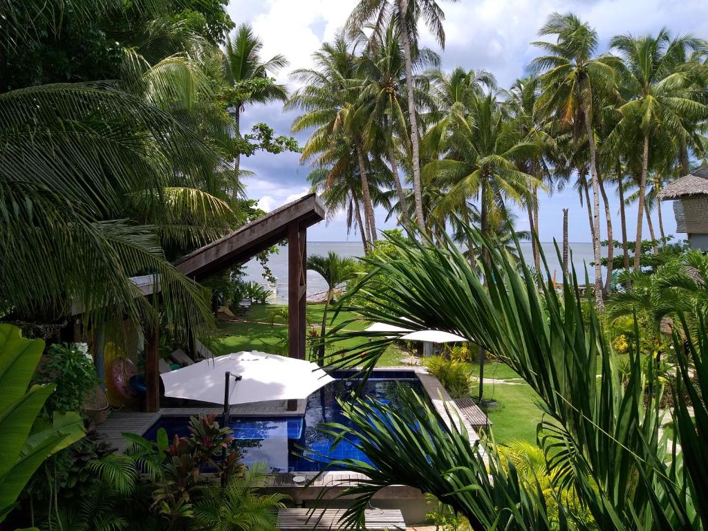 卢纳将军城Daluyong Beach Resort的一个带游泳池和棕榈树的度假村