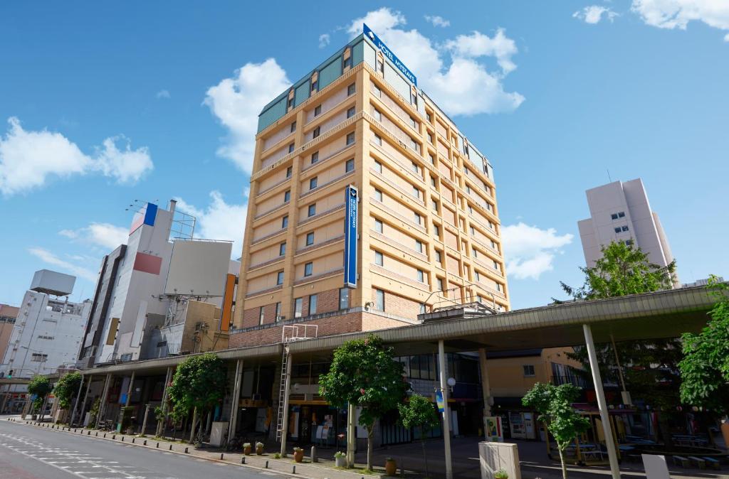 青森HOTEL MYSTAYS Aomori Station的一条城市街道上高大的黄色建筑