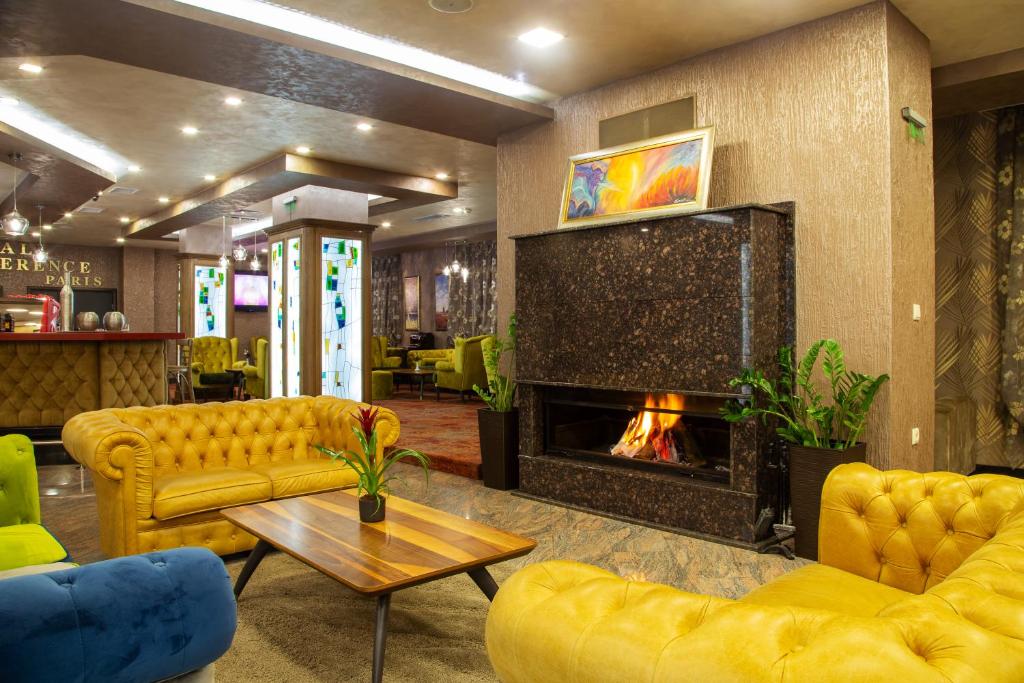 韦林格勒巴尔尼奥Spa水疗酒店的客厅配有黄色家具和壁炉