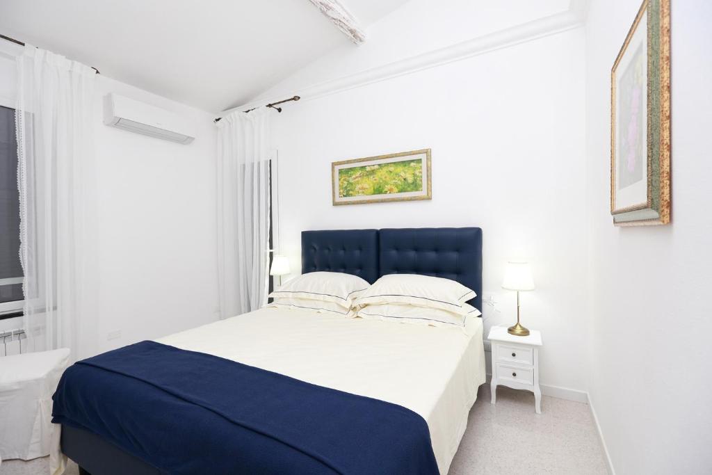 蒙特罗索阿尔马雷Come Eravamo的白色卧室配有蓝色和白色的床