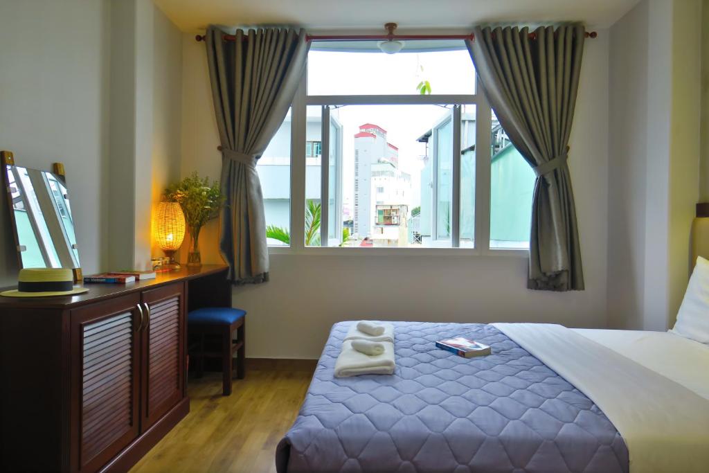 胡志明市Giang Son Hotel 江山民宿胡志明市的一间卧室配有一张床、一个窗口和一张书桌