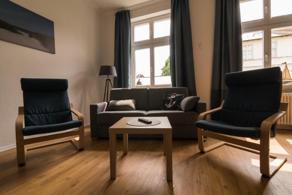 施特拉尔松德Ferienwohnung Sundkieker的客厅配有沙发、两把椅子和一张桌子