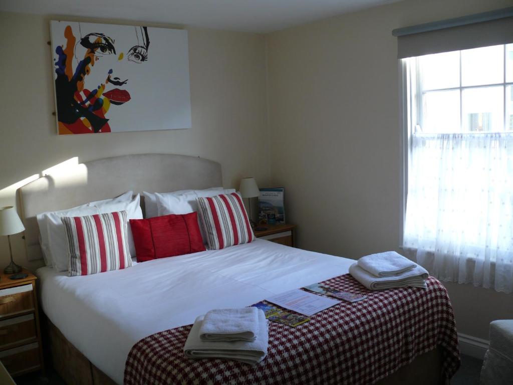 布莱顿霍夫弓街跑步者酒店的一间卧室配有一张床,上面有两条毛巾