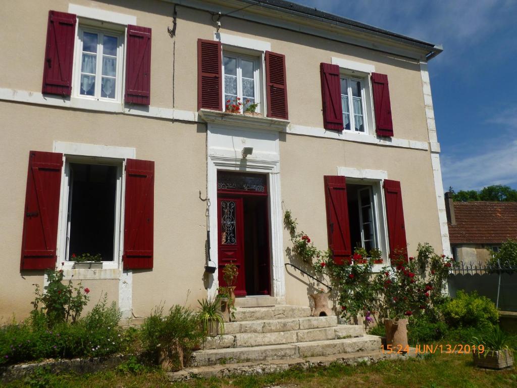 Druyes-les-Belles-FontainesGite des Belles Fontaines的红色百叶窗和红色门的房子