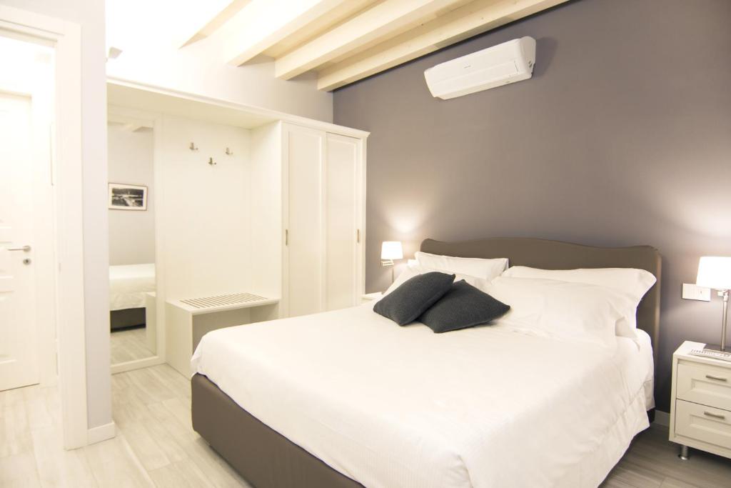 伊塞奥LA QUADRA SUITES - Central Apartments in Iseo的卧室配有一张带两个枕头的大白色床