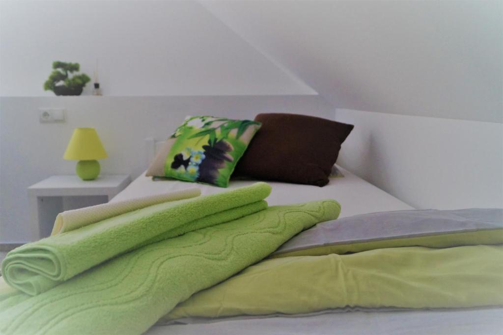 巴特塞格贝格Ferienzimmer Segeberg的一张带绿毛毯和枕头的床