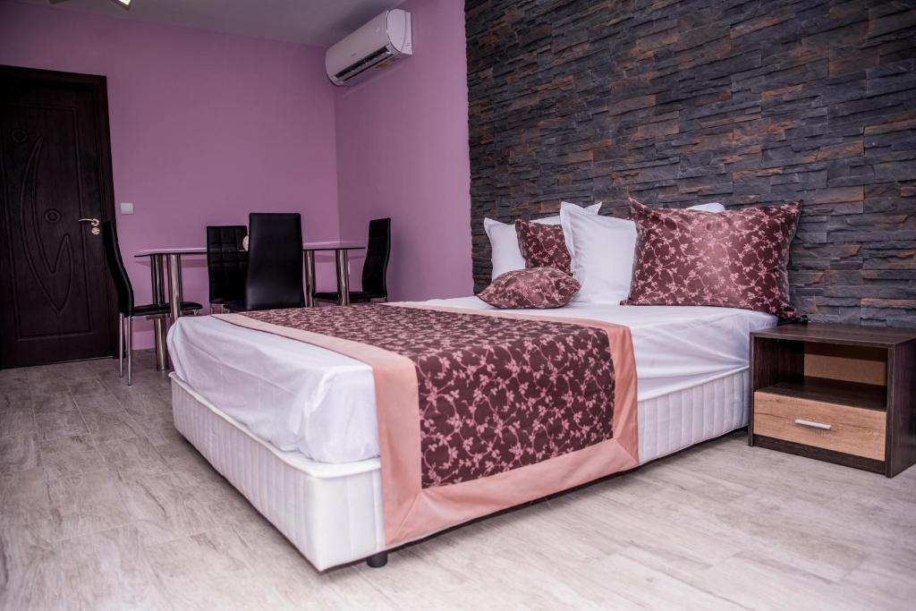 大特尔诺沃Апартамент България 41的一间卧室设有一张大床和砖墙