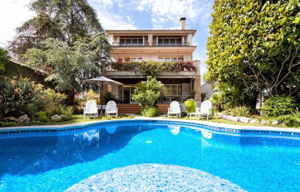 卡里拉Villa Paquita的房屋前有游泳池的房子