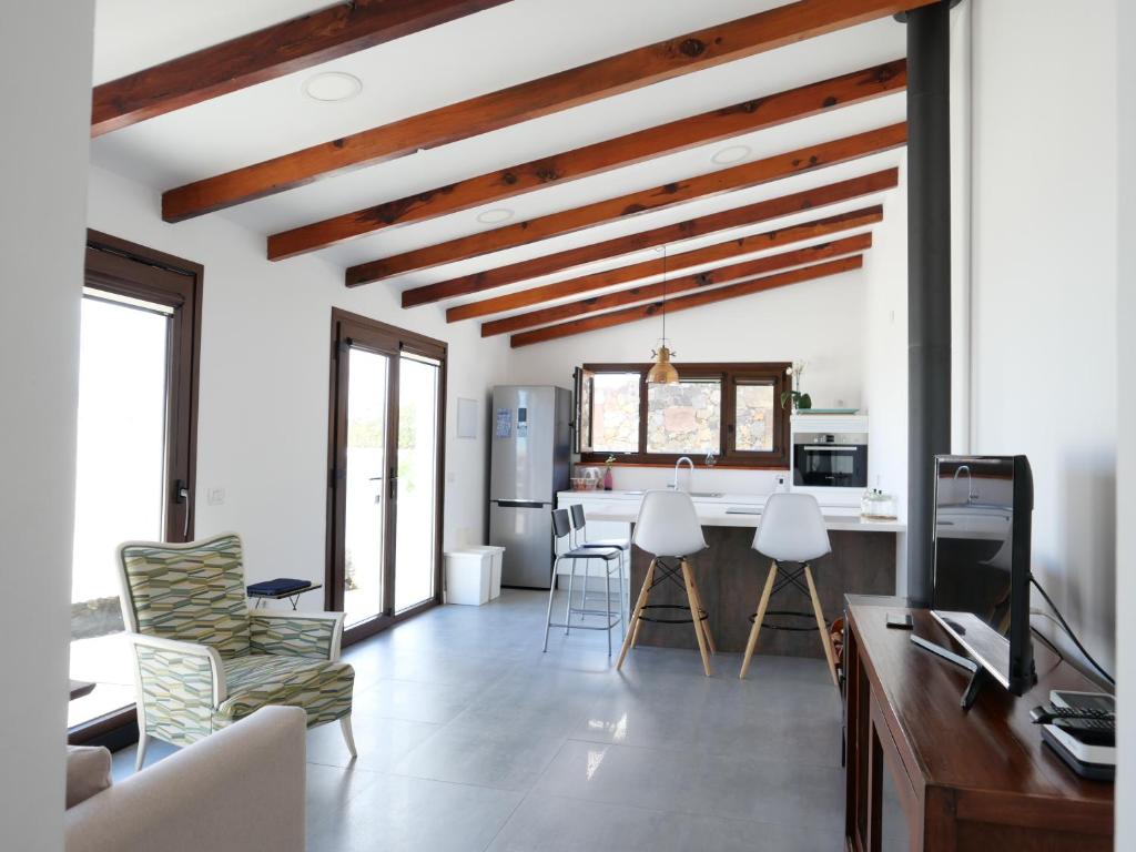 El Pinar del HierroCasa Viges的厨房以及带白色墙壁和木制天花板的客厅。