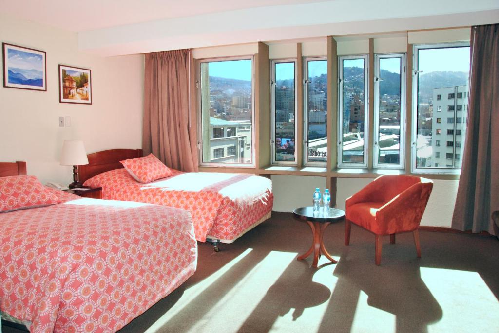 拉巴斯凯莱拉巴斯酒店的酒店客房带两张床、椅子和窗户