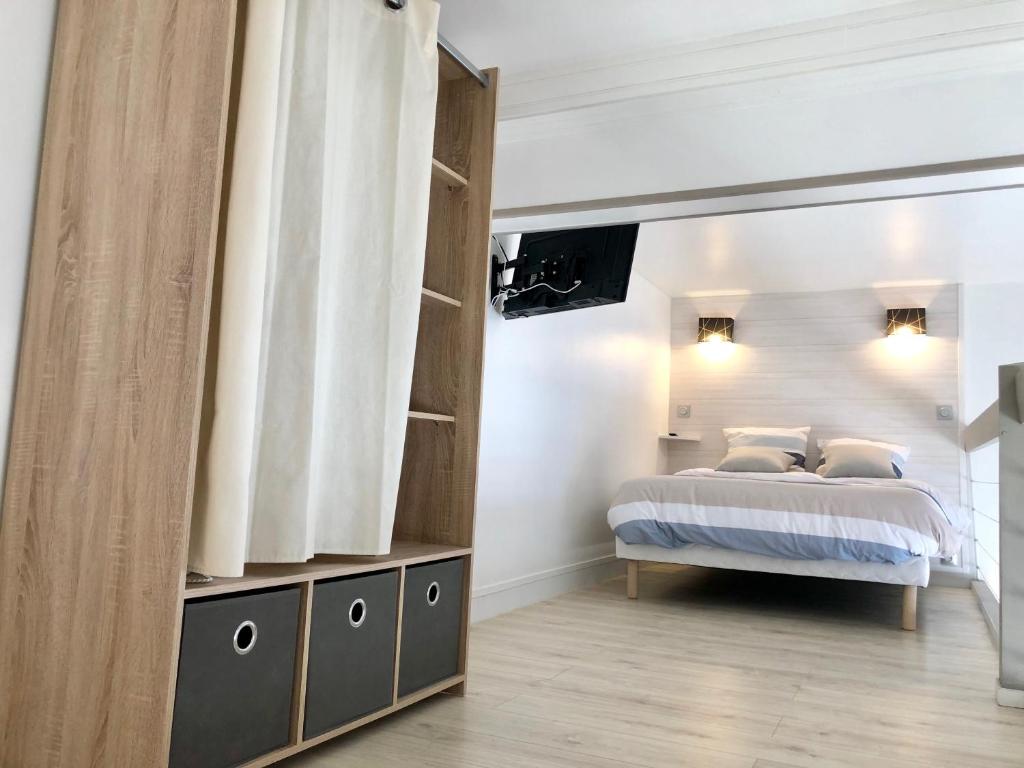 滨海图维列Charmant Duplex Trouville-Deauville的一间卧室配有一张床,墙上配有电视