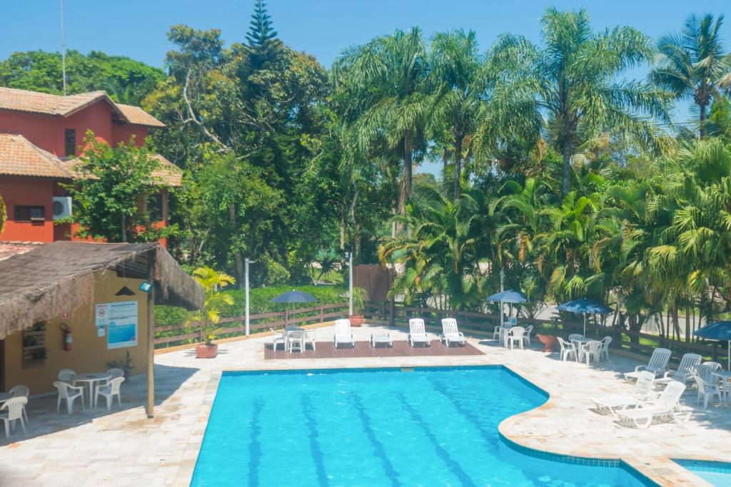伯迪亚哥Flat com serviços na Riviera的度假村的游泳池,配有椅子和遮阳伞