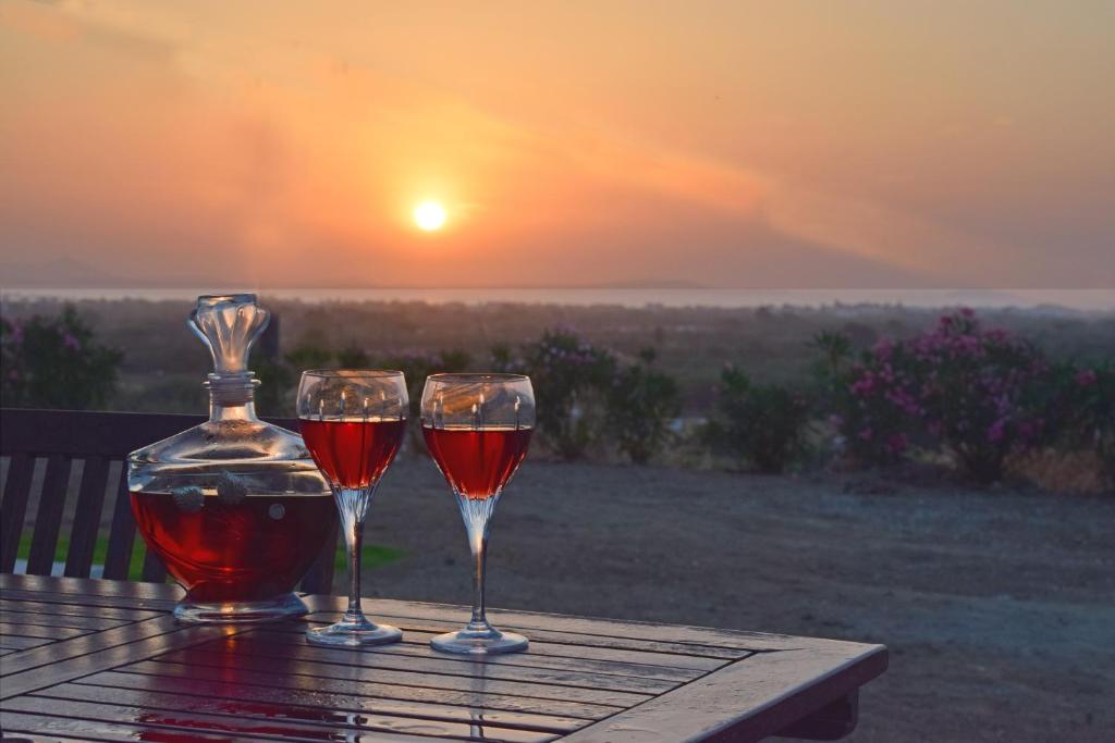 纳克索乔拉Naxian vacation with sea view的两杯酒坐在桌子上,欣赏日落美景