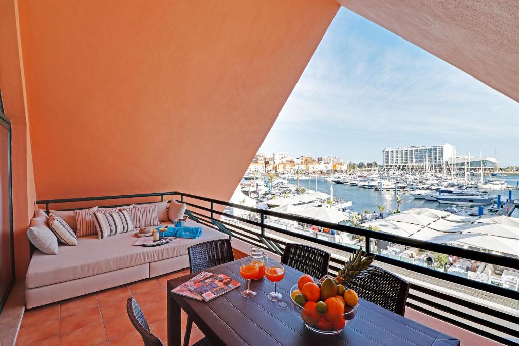 维拉摩拉Marina Princess的阳台配有沙发和桌子,享有海港景色