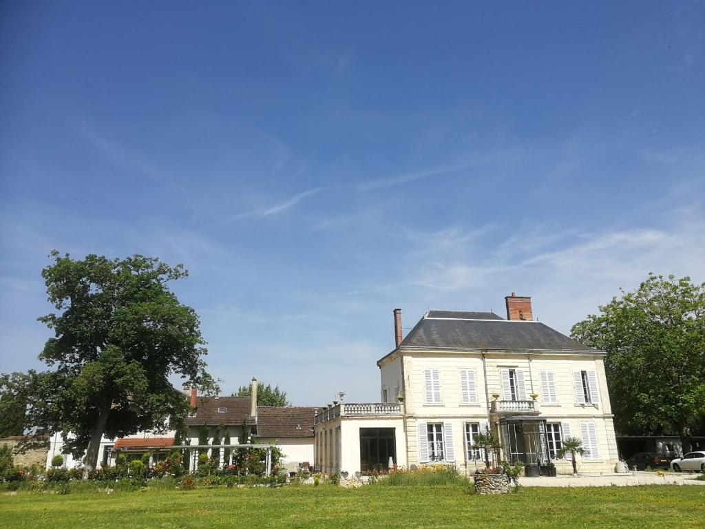 Val de VesleChâteau de Courmelois Champagne Guest House的一座大型白色房子,设有大院子