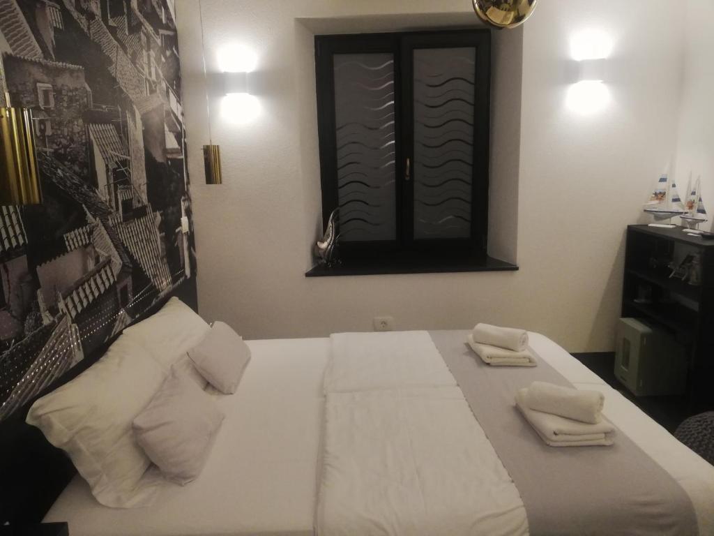 皮兰Camera al Porto Antico的一间卧室配有一张床,上面有两条毛巾