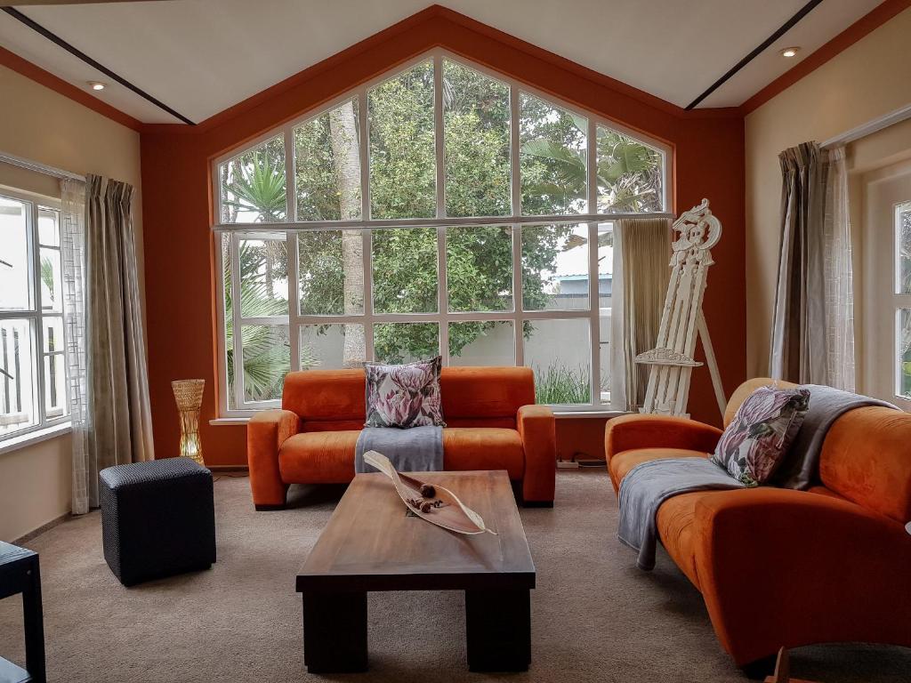 斯瓦科普蒙德9 on Kiebitz的客厅配有橙色家具和大窗户