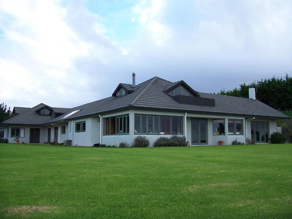 Mahinepua怀瓦里埃海岸农场旅馆的前面有绿色草坪的房子