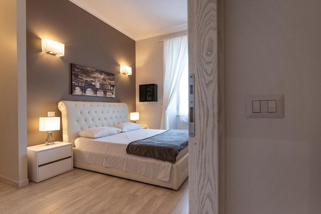 罗马中央梵蒂冈客房旅馆的一间卧室配有一张床、两盏灯和一个窗户。