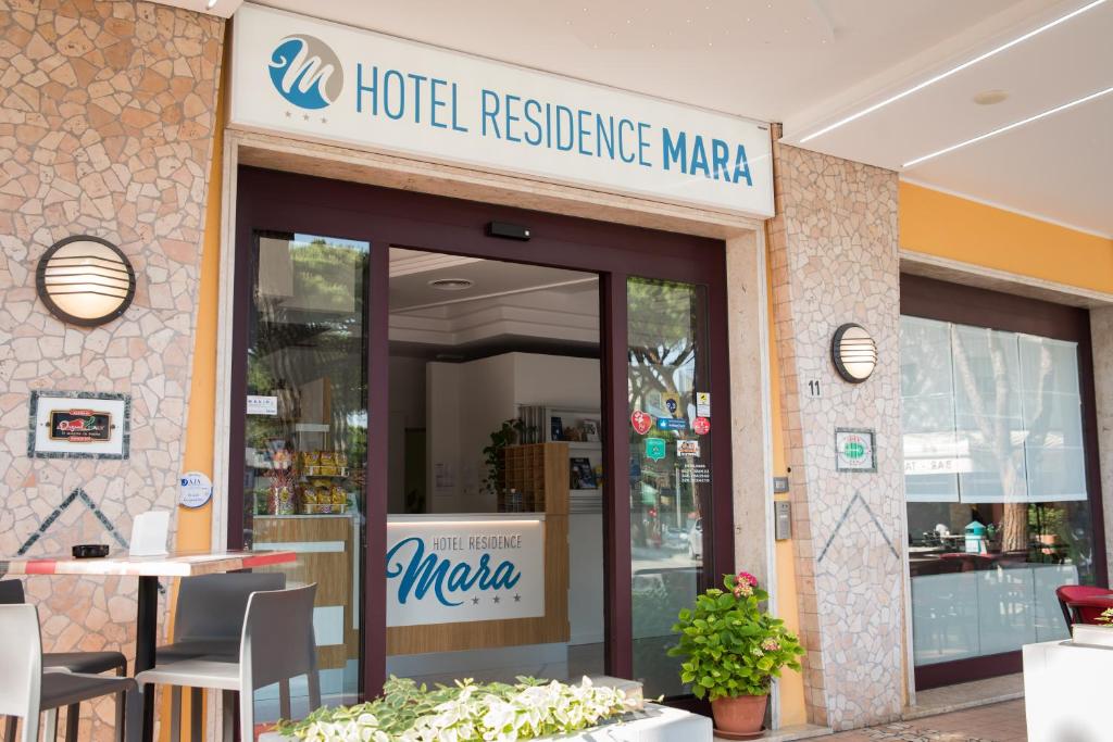 利多迪耶索罗Hotel Residence Mara的一间酒店餐厅,前面有标志