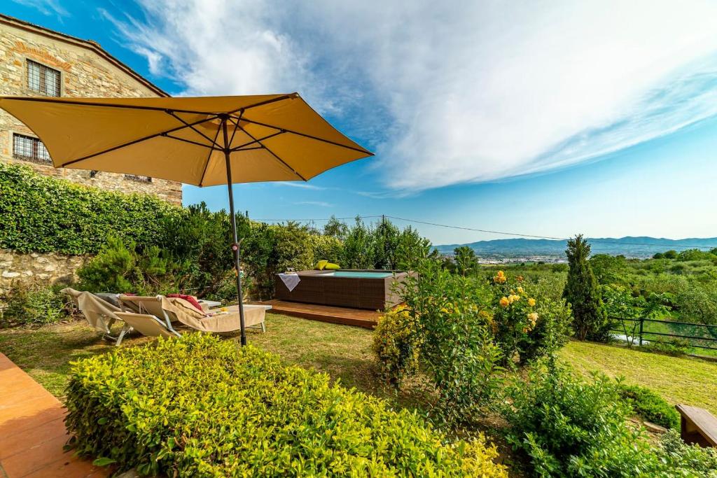 蒙泰穆尔洛Villa San Giorgio的一个带遮阳伞、长凳和灌木的庭院