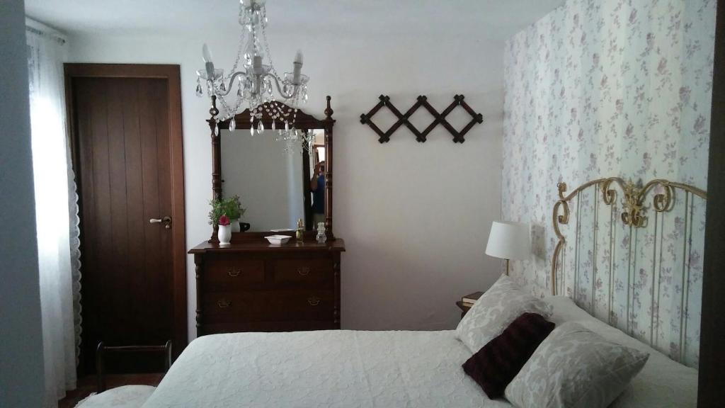 科迪加纳María的一间卧室配有一张床、梳妆台和镜子