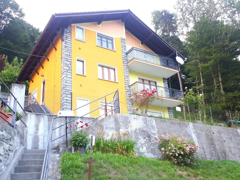 大圣玛丽亚Appartamento la Canvetta的山上的黄色房子,有楼梯和鲜花