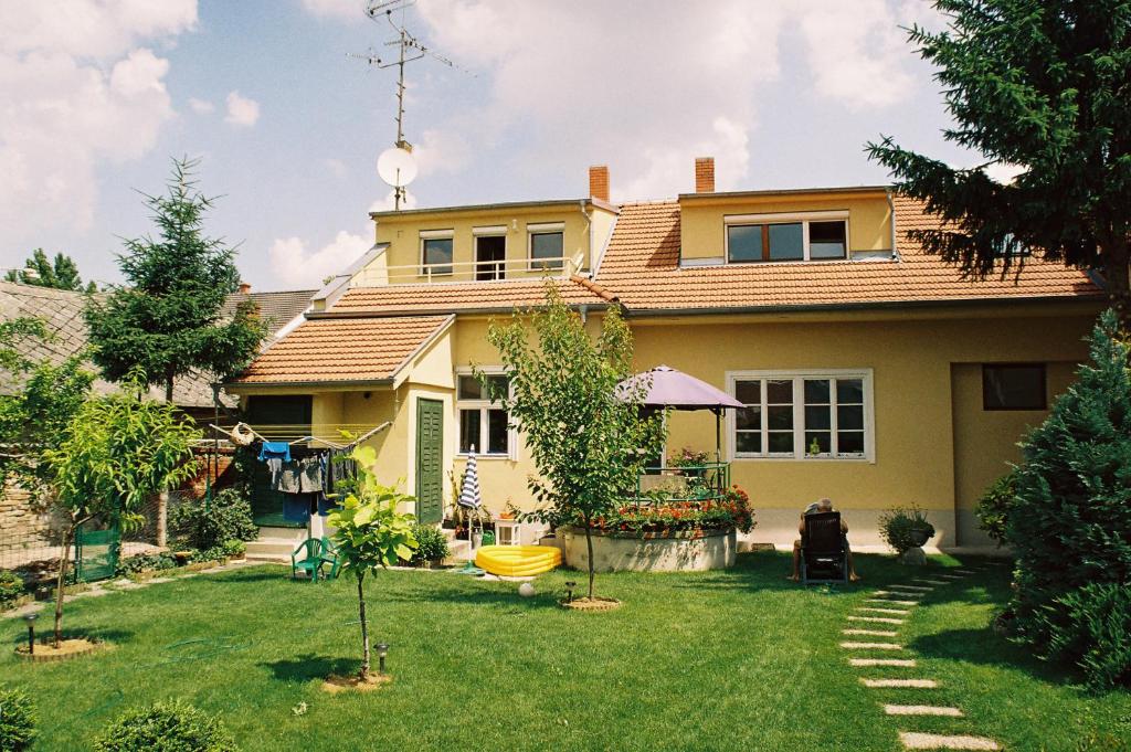 科马尔诺Apartmán Silvia的一座黄色的房子,有树庭院