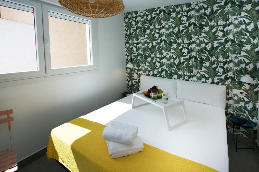 多列毛利诺斯MONKÓ - BANANA & TROPYCAL APARTMENT o的一间卧室配有一张黄色和白色毯子的床