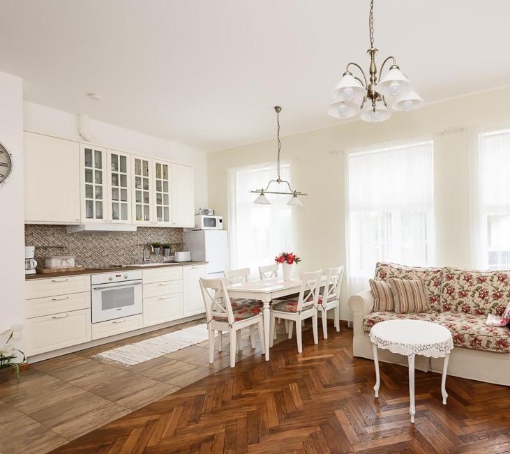 派尔努Roosi Apartment的白色的厨房配有桌子和沙发