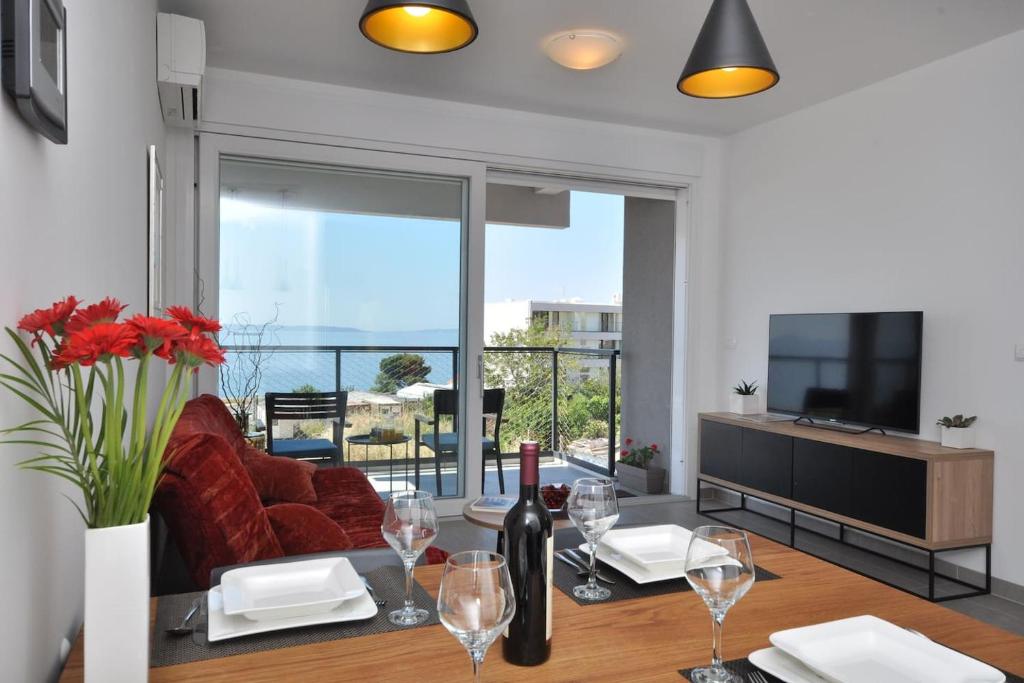 斯普利特Apartment Carmen, Žnjan, Split的客厅配有沙发和带酒杯的桌子