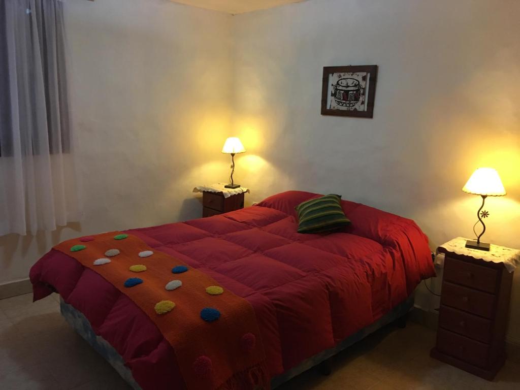 塔菲德尔瓦勒Cabañas Ernes Huasi的一间卧室配有一张红色大床和两盏灯