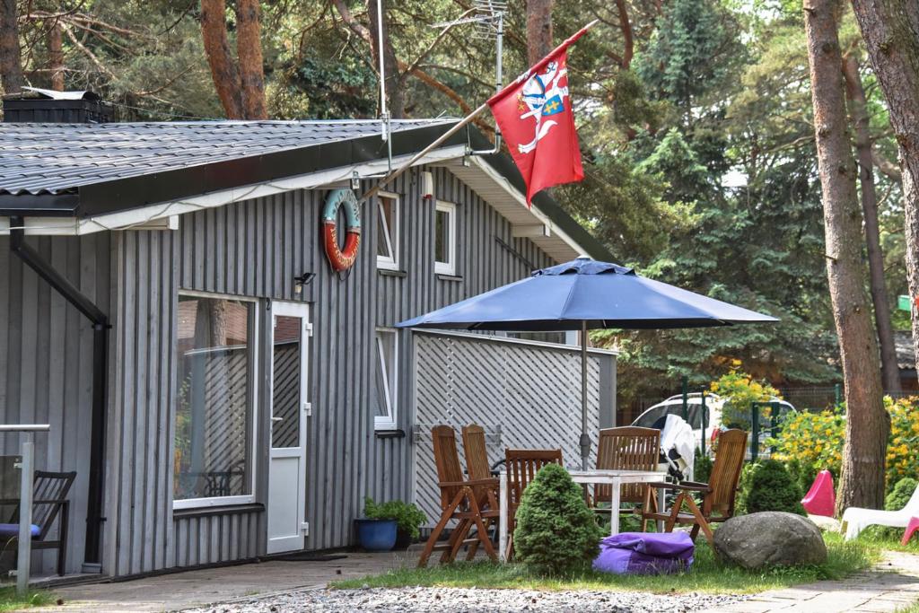 斯文托伊Undinėlė的一座带旗帜、桌子和雨伞的房子
