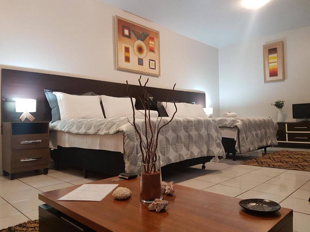 阿纳波利斯B & A Suites Inn Hotel - Quarto Luxo Premium的一间卧室配有一张床和一张木桌及木桌