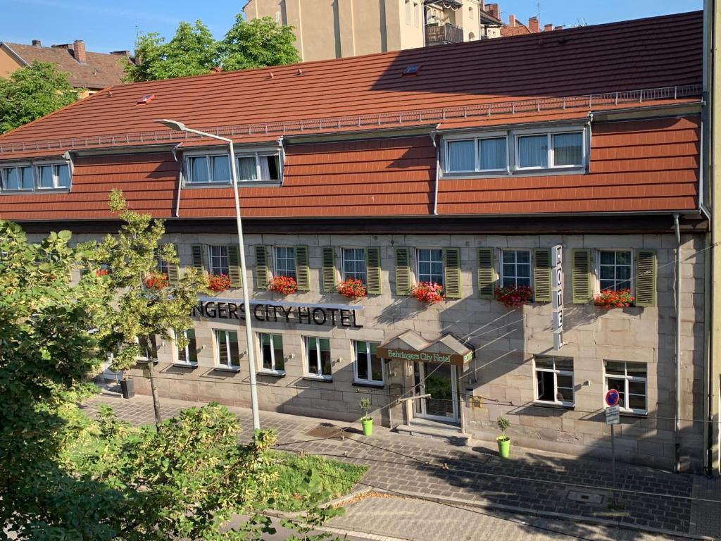 纽伦堡纽伦堡贝林尔斯城市酒店的一座建筑,屋顶红色,窗户上摆放着鲜花
