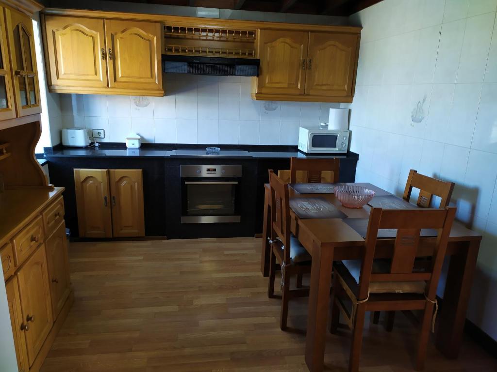 卡尔诺塔Casa de Xusto的厨房配有木制橱柜和桌椅