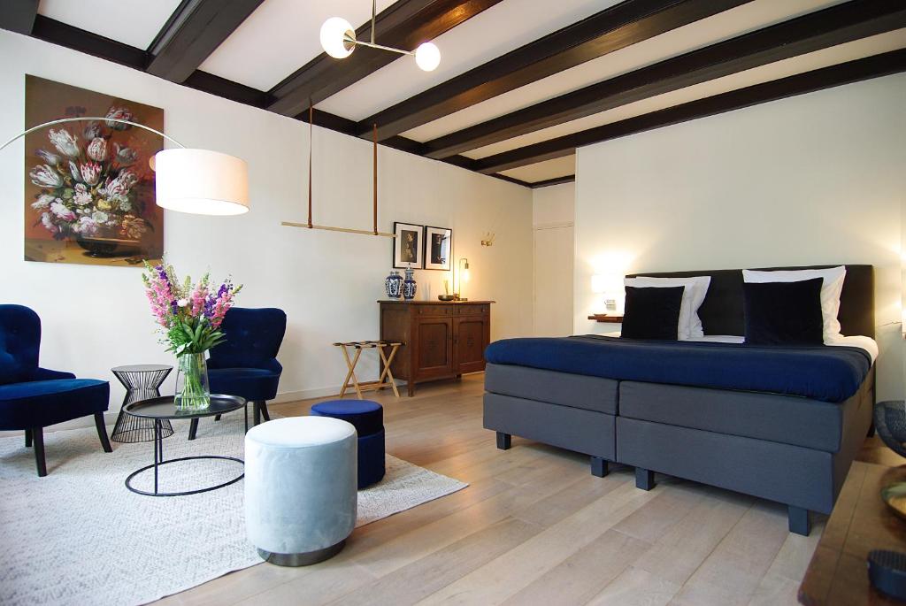 阿姆斯特丹1637: Historic Canal View Suites的一间带蓝色床的卧室和一间客厅