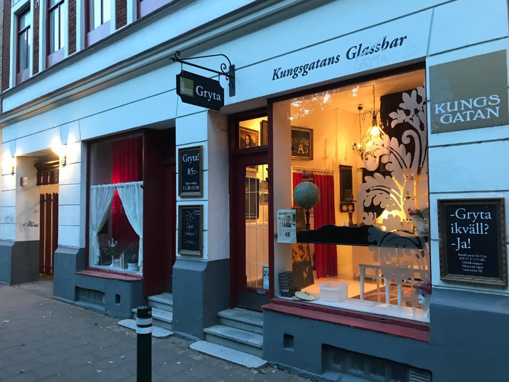 马尔默Kungsgatans Gryta & Hotell的商店前方有读过华氏古典主义和国王的标志