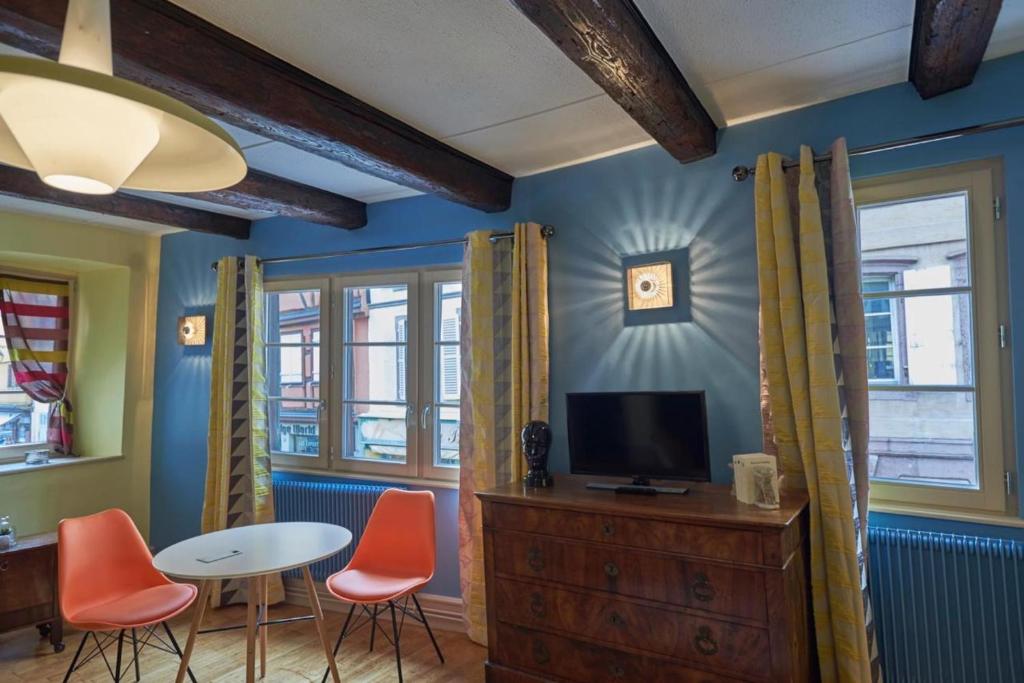 科尔马Maison Cliquot - Appartements Colmar Centre的客厅配有电视和桌椅