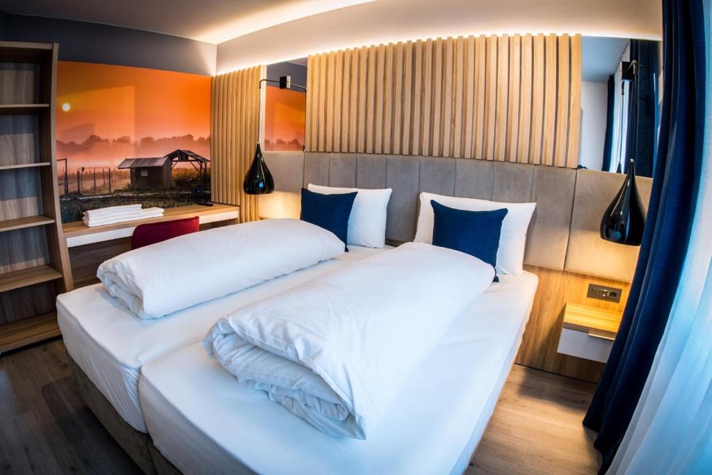 拉克斯道夫维尔德曼恩酒店的卧室配有带蓝色枕头的大型白色床
