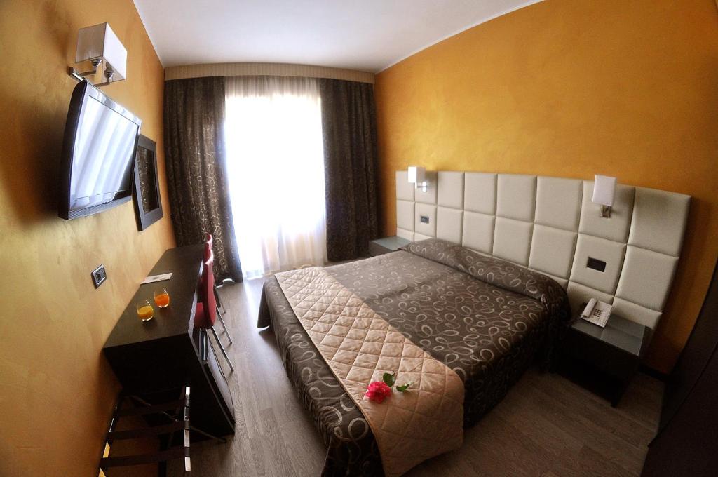 瓦拉泽克丽斯塔罗酒店的一间卧室设有一张床和一个带电视的窗户。
