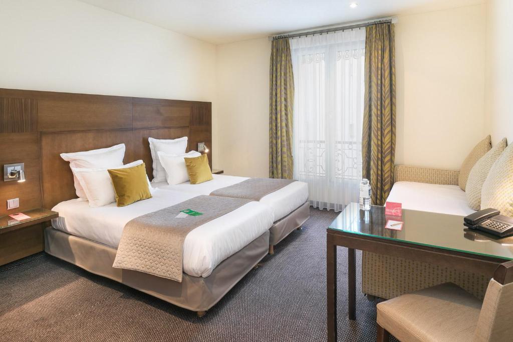巴黎Hôtel Le Cardinal的酒店客房配有两张床和一张书桌