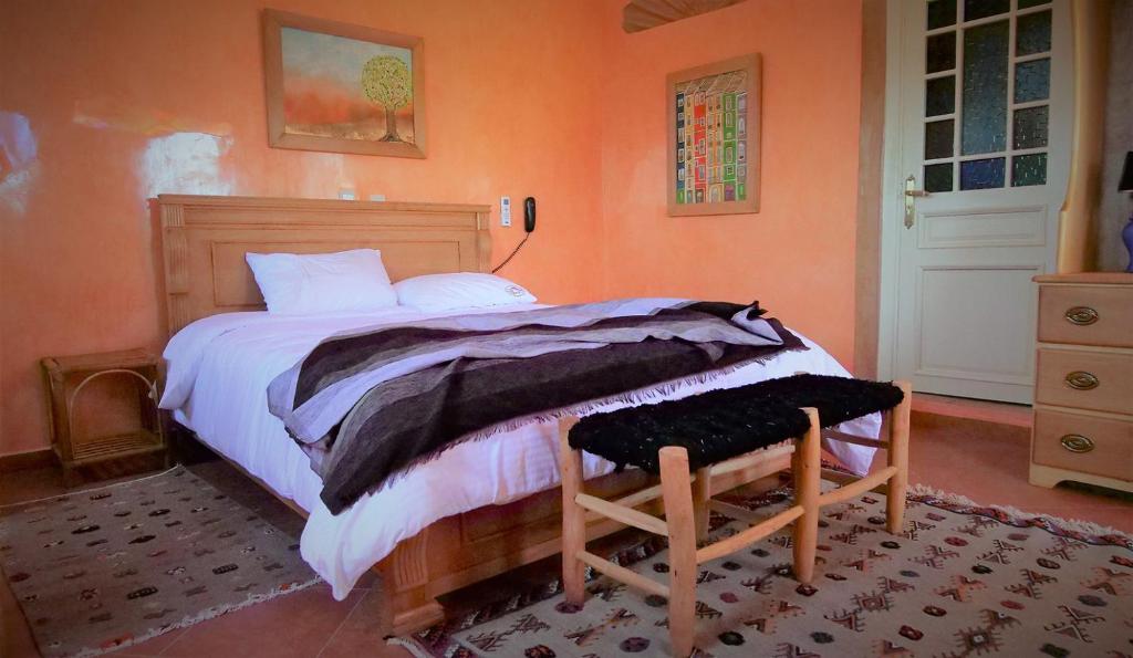 卡萨布兰卡Ryad 91的一间卧室配有一张带橙色墙壁的大床