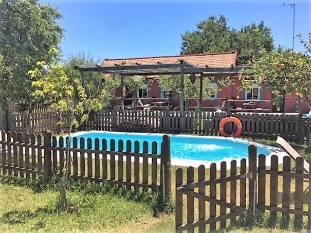 卡萨雷斯Karma House的房屋前方带游泳池的木栅栏