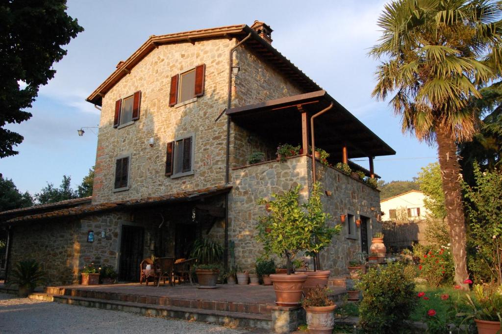 Terontola卡萨迪娜住宿加早餐旅馆的一座棕榈树的古老石头房子
