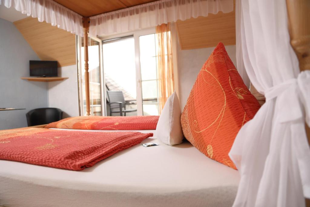 特赖斯-卡尔登科奈普旅馆的一间卧室配有两张带橙色枕头的床和窗户。