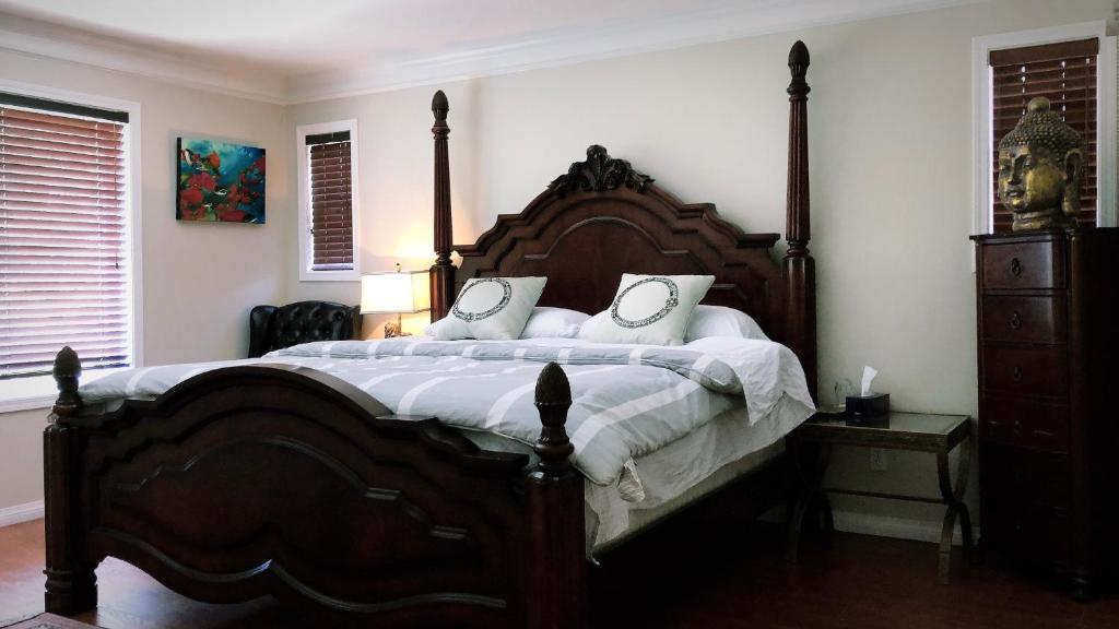 里士满Royalty B&B的卧室配有带白色枕头的大型木质床。