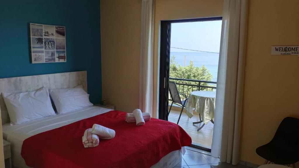 斯卡拉卡里拉奇斯Villa Marianna的一间卧室配有一张带红色毯子的床和一个阳台