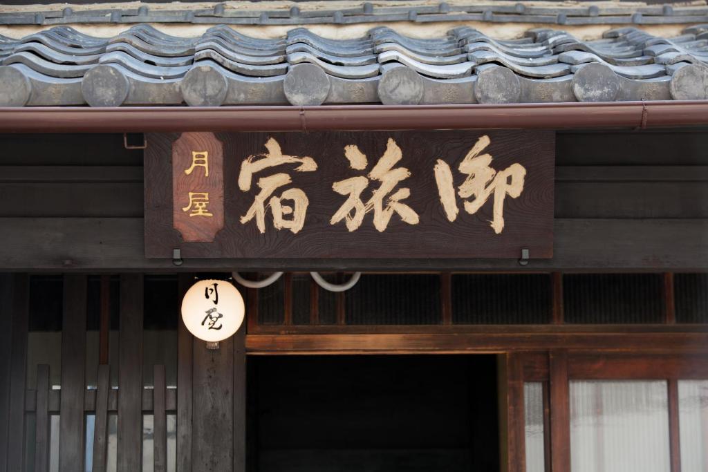 京都Bed & Breakfast Tsukiya的建筑上写着中国文字的标志